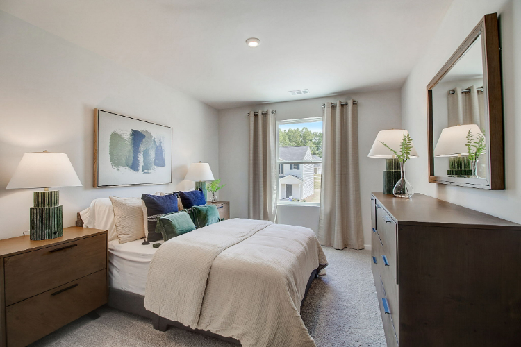 A bedroom with a large mirror.