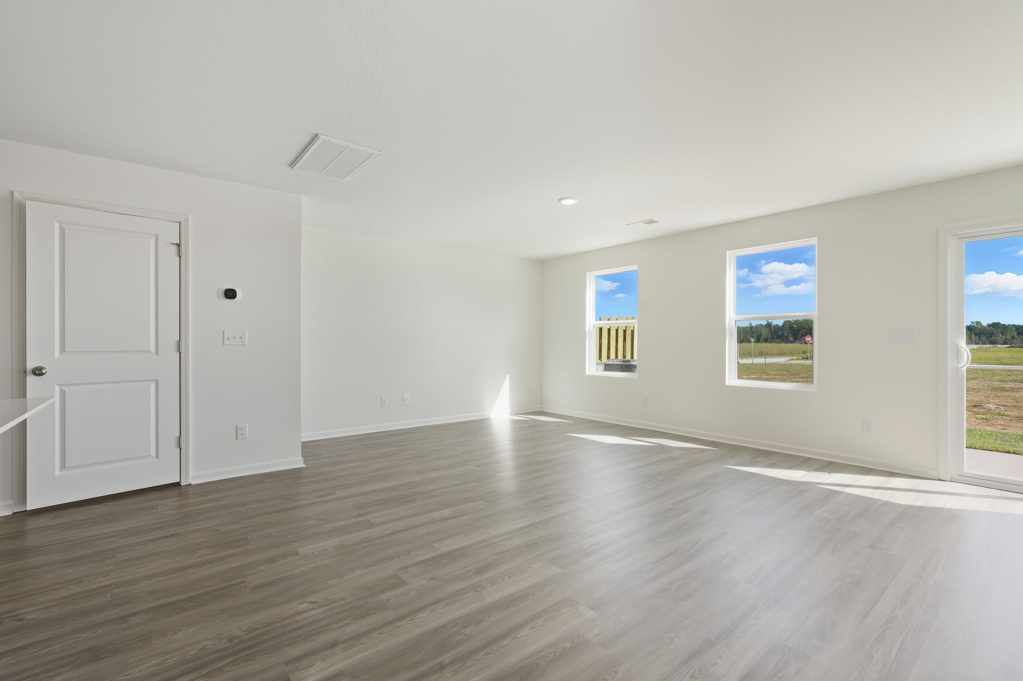 A room with white doors and a wood floor.