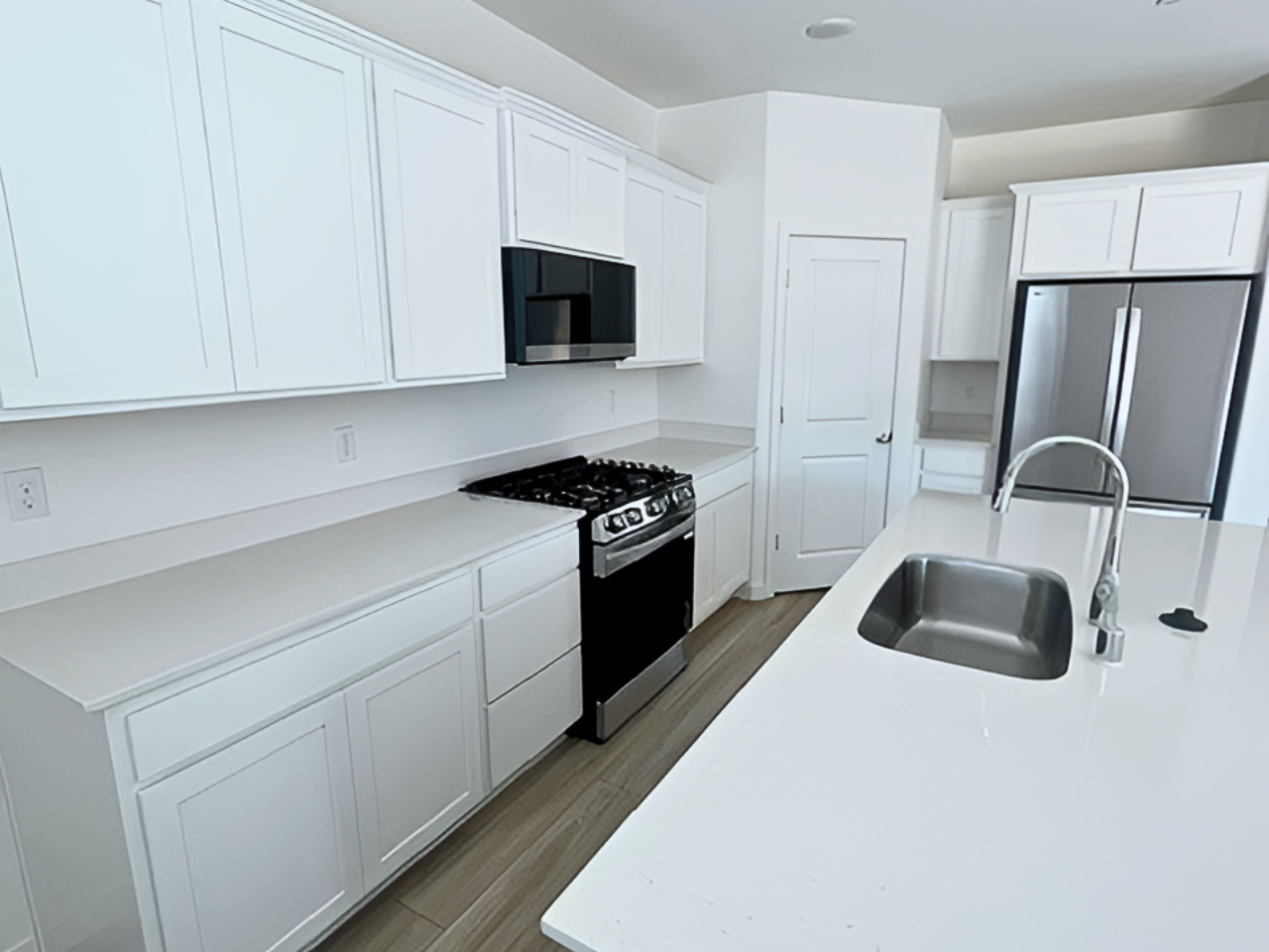 A kitchen with white cabinets.